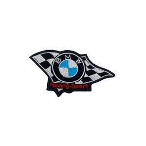 Op de afbeelding: Geborduurde patch met het BMW-logo op een geblokte vlag. Het logo heeft een blauw-wit geblokt midden, met de letters "BMW" eromheen. De woorden "Racing Sport" zijn rood.