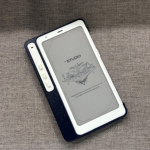 May include: A white tablet with a dark blue case. The screen displays a graphic of a city and the text "OF STUDIO". Below the graphic, the text reads "INNOVATION AND SMART PRODUCTS FOR A BETTER EXPERIENCE".