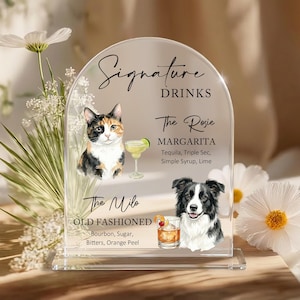 Könnte beinhalten: Transparenter Acrylschild mit der Aufschrift "Signature Drinks". Es zeigt Illustrationen einer Katze und eines Hundes mit Rezepten für Margarita und Old Fashioned Cocktails. Zutaten sind enthalten.