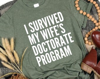 I Survived My Wife's Doctorate Program Shirt,Gift For Husband,Funny PHD Graduation Tee,PHD Dissertation Tshirt,Ironic Shirt,Grad Gag Shirt