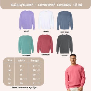Może przedstawiać: Bluzy Comfort Colors 1566 w kolorach fioletowym, białym, dżinsowym, morskim, karmazynowym i pieprzowym. Tabela rozmiar&oacute;w pokazuje wymiary w cm dla rozmiar&oacute;w od S do 2XL. Osoba prezentuje karmazynową bluzę.