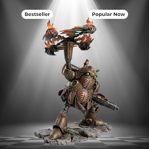 May include: A bronze-coloured mechanical figurine standing on a rocky base, featuring a rounded torso with ribbed panels, a large cannon on one arm, and a raised arm holding a rotating chain weapon with orange and yellow painted flame effects.