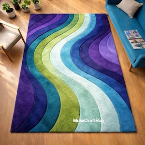 May include: A rectangular area rug with a wavy design in shades of purple, blue, green, and white. The rug features a textured surface and is placed on a wooden floor. The rug's design creates a sense of movement and adds a vibrant touch to the room.
