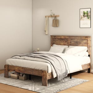 May include: A wooden bed frame with a headboard, covered with white bedding and a gray blanket. The bed sits on a patterned rug. Two small wicker baskets are placed under the bed. A picture hangs on the wall.