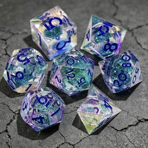 Puede incluir: Un juego de siete dados poliédricos hechos de resina transparente, cada uno con un núcleo brillante de purpurina color verde azulado y morado. Los dados presentan números grabados en azul oscuro en sus superficies facetadas, incluyendo un d20, d12, d10, d8, d6, d4 y un dado de porcentaje.
