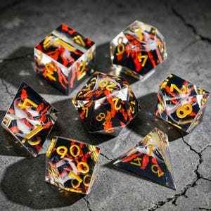 May include: Set of seven polyhedral dice with a black, red, and white marbled design. The dice have gold-colored numbers. The dice are in various shapes, including a cube, a d20, and a d4, suitable for tabletop role-playing games.