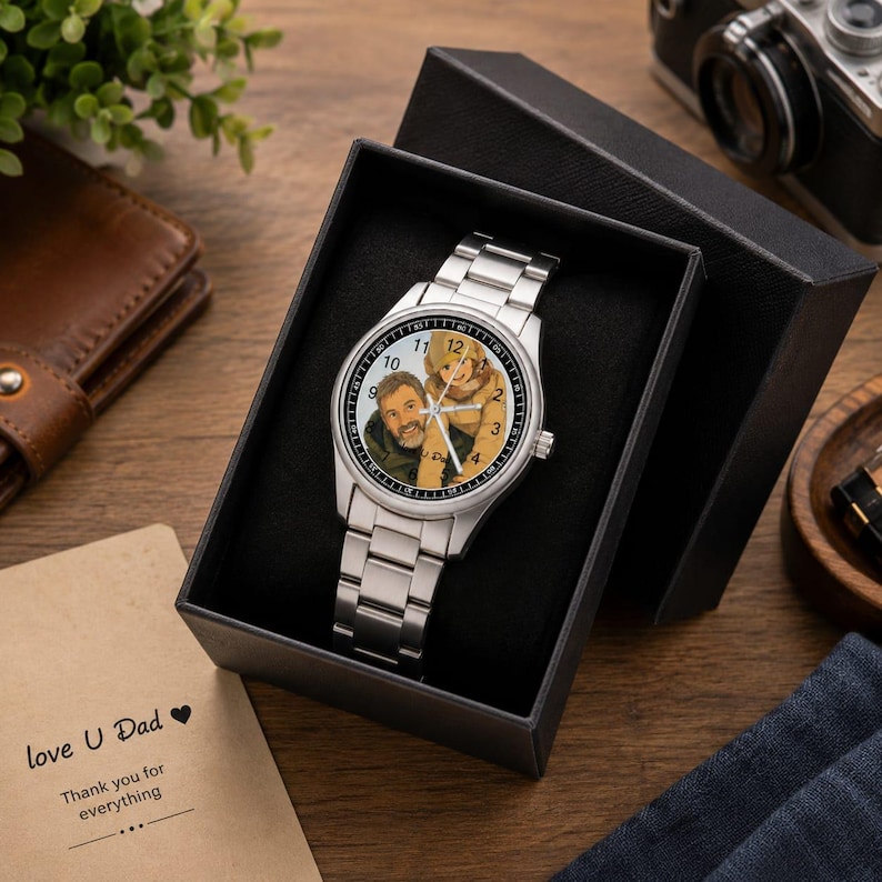 Puede incluir: Un reloj anal&oacute;gico de tono plateado con correa de eslabones met&aacute;licos, que presenta una ilustraci&oacute;n personalizada de dos personas en la esfera. El reloj se presenta dentro de una caja de regalo negra, acompa&ntilde;ado de una tarjeta con el texto love U Dad Thank you for everything.