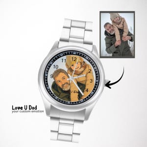 Puede incluir: Un reloj de pulsera anal&oacute;gico plateado con una ilustraci&oacute;n personalizada de una persona cargando a un ni&ntilde;o sobre sus hombros en la esfera. La esfera incluye n&uacute;meros y manecillas negras. Una peque&ntilde;a foto insertada muestra la imagen original.