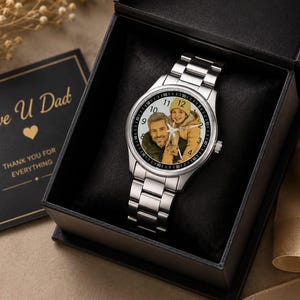 Puede incluir: Un reloj anal&oacute;gico de tono plateado con una esfera de foto personalizada que muestra a un adulto y a un ni&ntilde;o. El reloj tiene una correa de eslabones de metal y se presenta en una caja de regalo negra con una tarjeta que dice Love U Dad THANK YOU FOR EVERYTHING.