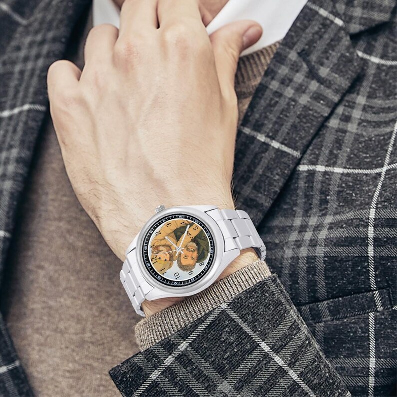 Puede incluir: Un reloj de pulsera anal&oacute;gico de tono plateado con una esfera blanca que presenta una ilustraci&oacute;n personalizada de dos personas. El reloj tiene una correa de eslabones met&aacute;licos y un bisel circular, con marcadores de hora y manecillas finas.