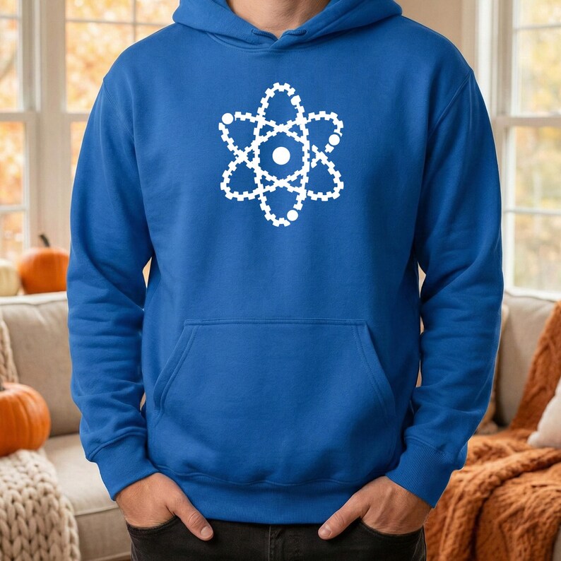 May include: Royal blue hoodie featuring a white atom graphic. The hoodie has a front pocket and a drawstring hood. The atom graphic is a stylized representation of an atom's structure.