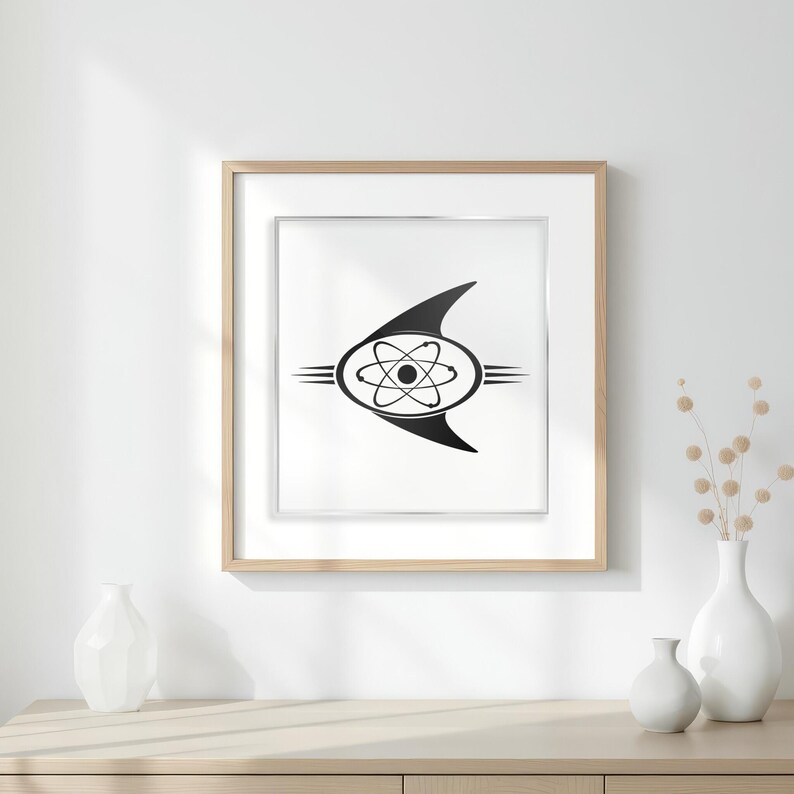 May include: Framed black and white print with a retro-futuristic atom symbol design. The artwork is set against a white background, framed in light wood. The print is displayed on a wooden surface with white vases. The frame is approximately 30 cm x 40 cm.