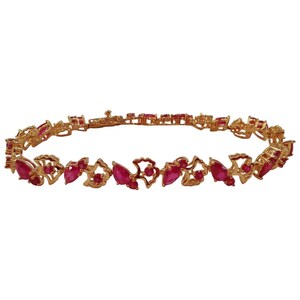 May include: A gold bracelet with red ruby stones set in a floral design.
