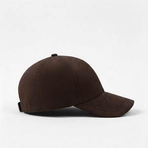 K&ouml;nnte beinhalten: Braune Baseballkappe mit gebogenem Schirm. Die Kappe hat eine runde Krone und einen kleinen Knopf oben. Sie besteht aus einem weichen, strukturierten Material und hat ein schlichtes, klassisches Design.