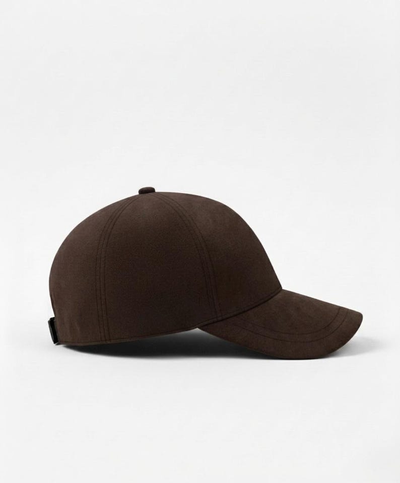 K&ouml;nnte beinhalten: Braune Baseballkappe mit gebogenem Schirm. Die Kappe hat eine runde Krone und einen kleinen Knopf oben. Sie besteht aus einem weichen, strukturierten Material und hat ein schlichtes, klassisches Design.