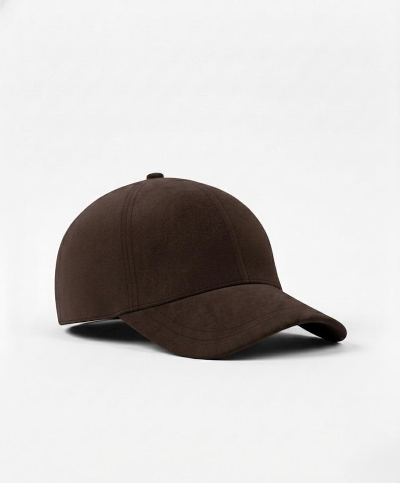 K&ouml;nnte beinhalten: Eine einfarbige, braune Baseballkappe mit gebogenem Schirm. Die Kappe hat ein sechsteiliges Design und einen kleinen Knopf oben. Der Hut ist aus einem weichen, strukturierten Material gefertigt.