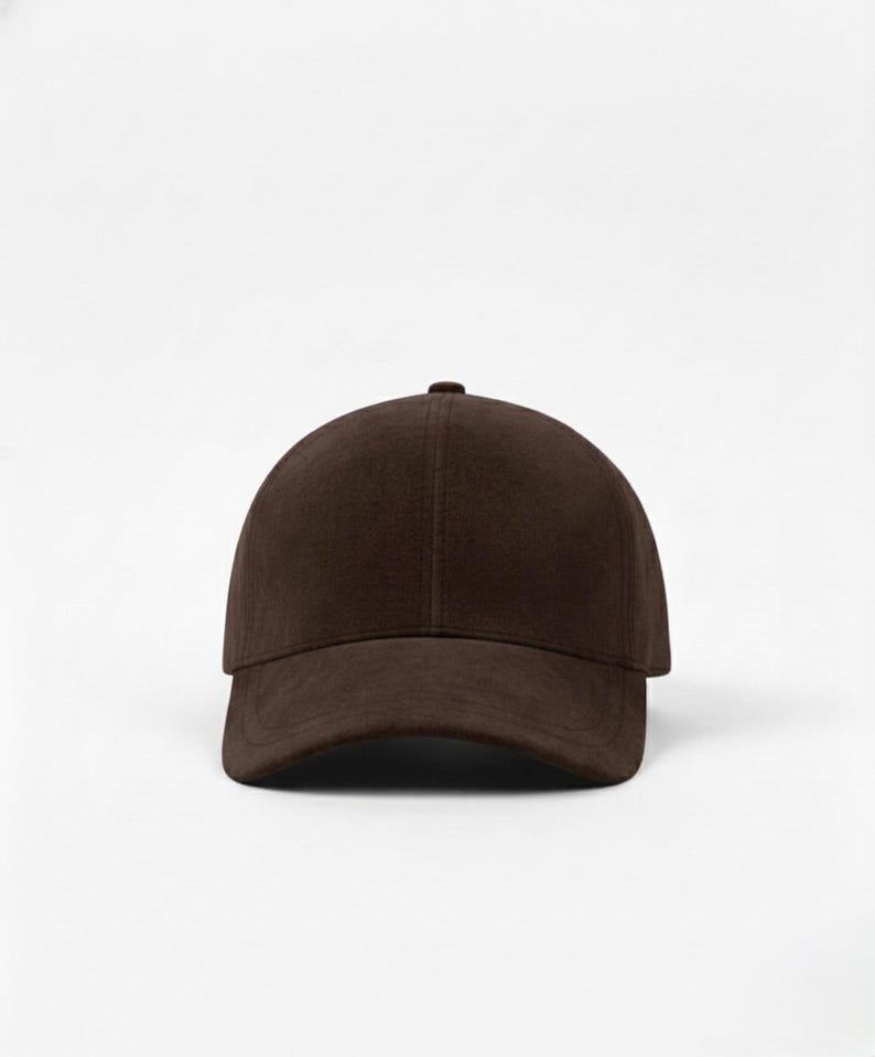 K&ouml;nnte beinhalten: Einfarbige braune Baseballkappe mit gebogenem Schirm. Die Kappe hat ein klassisches Sechs-Panel-Design und einen kleinen Knopf oben. Der Hut ist aus einem weichen, strukturierten Material gefertigt.