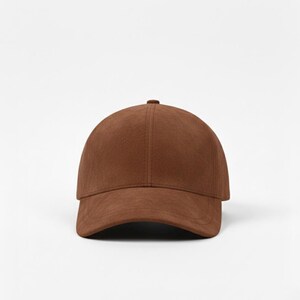 K&ouml;nnte beinhalten: Einfarbige braune Baseballkappe mit gebogenem Schirm. Die Kappe besteht aus einem weichen, Wildleder-&auml;hnlichen Material und hat ein klassisches sechsteiliges Design. Die Krone ist abgerundet und der Schirm leicht gebogen.