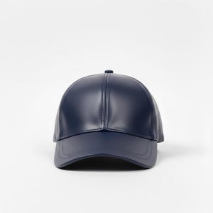 Könnte beinhalten: Eine marineblaue Baseballkappe mit gebogenem Schirm. Die Kappe besteht aus einem glatten Material und hat ein klassisches Sechs-Panel-Design. Der Hut ist einfarbig und hat einen Knopf oben.