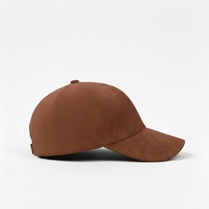 K&ouml;nnte beinhalten: Braune Baseballkappe mit gebogenem Schirm. Die Kappe besteht aus einem weichen Material und hat ein klassisches Sechs-Panel-Design. Die Kappe ist einfarbig und hat einen kleinen Knopf oben.