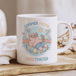 Puede incluir: Taza de cerámica blanca con un cerdo de dibujos animados con gafas de sol relajándose en una piscina. La taza tiene las palabras "SUMMER MOOD" y "OINKTIVATED" impresas, con una ilustración de escena de playa.