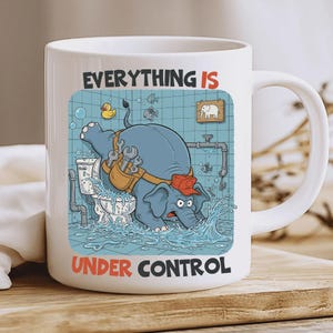 Puede incluir: Taza de cerámica blanca con un elefante de dibujos animados fontanero en una escena de baño. El elefante, con una gorra roja y un cinturón de herramientas, está arreglando un inodoro. El texto en la taza dice "EVERYTHING IS UNDER CONTROL."