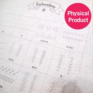 May include: A white fabric with various embroidery stitch examples, including straight, zigzag, and floral patterns. The word "Embroidery" is at the top, and the text "Physical Product" is in a red circle.