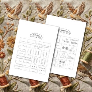 May include: Two white sheets with embroidery stitch diagrams labeled "Embroidery" sit on a linen surface with embroidered birds and flowers. Spools of brown and green thread are also visible, suggesting a crafting theme.