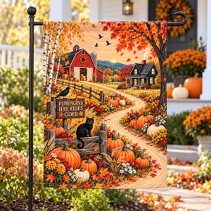 May include: A rectangular garden flag featuring an autumn farm scene with a red barn, a black house, pumpkins, and a black cat. A wooden sign reads PUMPKINS HAY RIDES CIDER. The landscape includes orange trees, a dirt path, and birds in the sky.
