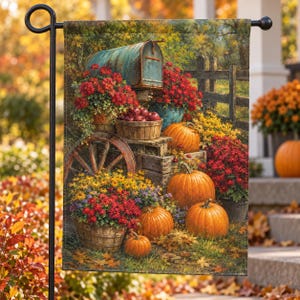 May include: A rectangular garden flag featuring a rustic scene with a weathered teal mailbox, a wooden wagon wheel, and several orange pumpkins. The display includes baskets filled with vibrant red and yellow autumn flowers and apples.