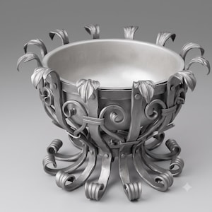 Può includere: Una ciotola in metallo color argento con un bacino interno liscio, sostenuta da una cornice decorativa di strisce metalliche curve a forma di voluta. Il bordo superiore è ornato da piccoli accenti metallici a forma di foglia e la base è formata.