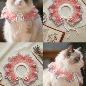 May include: A handmade, crochet cat collar in pink, white, and lavender. The collar has a scalloped edge and a white tie closure. The cat collar is shown on a fluffy, white cat with blue eyes.