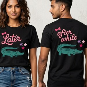 May include: Black t-shirts with matching designs. One shirt features the word "Later" with a pink bow and a green alligator graphic. The other shirt says "after while" with a pink bow and a green alligator graphic.