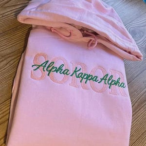 Puede incluir: Un juego de tres tazas de cerámica con un acabado mate moteado. Las tazas son de color crema, gris claro y gris oscuro. Cada taza tiene un diseño minimalista y un asa redondeada. Para café o té.