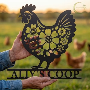 May include: Black metal rooster silhouette with floral cutouts, held in front of a blurred green field. The rooster has a decorative design with yellow and brown flowers. The text "ALY'S COOP" is displayed below the rooster.