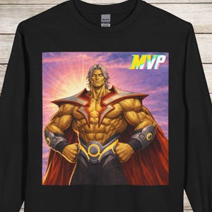 May include: Black long-sleeve shirt featuring a muscular superhero illustration with the word "MVP" in a colorful, stylized font. The superhero has gray hair, a red cape, and gold and silver accents.