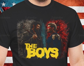 May include: Black t-shirt featuring a graphic from "The Boys" series. The design shows two characters with a split background of grey and red. The text "THE BOYS" is in yellow. The shirt is worn against an American flag.