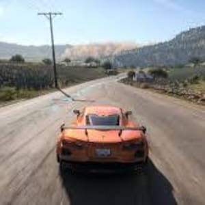 May include: An orange sports car speeds down a paved road, viewed from behind. The car's taillights are visible, and the road stretches into the distance, flanked by fields and hills under a bright sky. The speedometer reads 127.