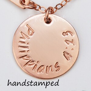 May include: Rose gold necklace with a round pendant that says "Philippians 4:13" hand-stamped on it.
