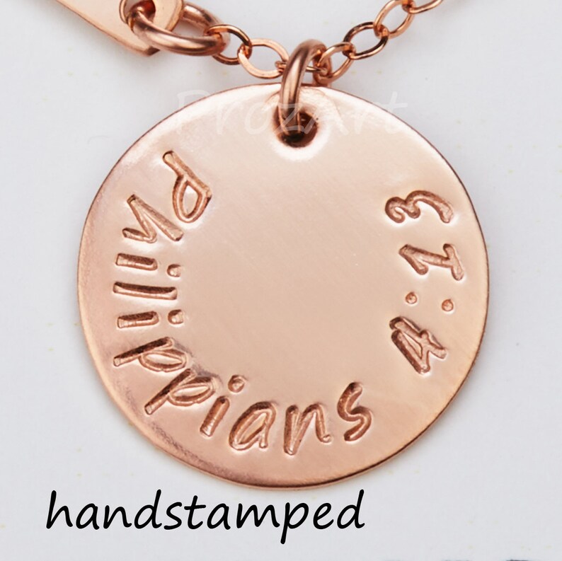 May include: Rose gold necklace with a round pendant that says "Philippians 4:13" hand-stamped on it.