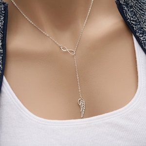 May include: A silver necklace with an infinity symbol and a dangling angel wing charm.