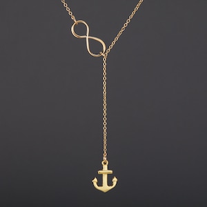 Peut inclure: Un collier en or avec un pendentif en forme d'infini et un pendentif en forme d'ancre.