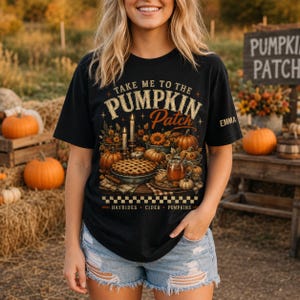 Peut inclure: Un t-shirt noir avec une impression graphique portant le texte "TAKE ME TO THE PUMPKIN PATCH" au-dessus d'une illustration de citrouilles, d'une tarte et d'une tasse de cidre. Le bas du motif inclut "HAYRIDES CIDER PUMPKINS" et "EMMA".
