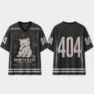 Könnte beinhalten: Ein schwarzes V-Ausschnitt-Trikot mit einer Katzen-Grafik und Binärcode. Die Vorderseite zeigt den Text BORN TO SLEEP FORCED TO EXIST ERROR 404: WILL TO LIVE NOT FOUND Please do not perceive me. Die Rückseite zeigt die große Zahl 404.