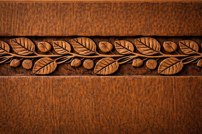 Puede incluir: Primer plano de una superficie de madera con un dise&ntilde;o tallado de hojas y vides. Las hojas est&aacute;n detalladas con vetas visibles, y la madera tiene un tono marr&oacute;n c&aacute;lido. La talla forma un borde decorativo.