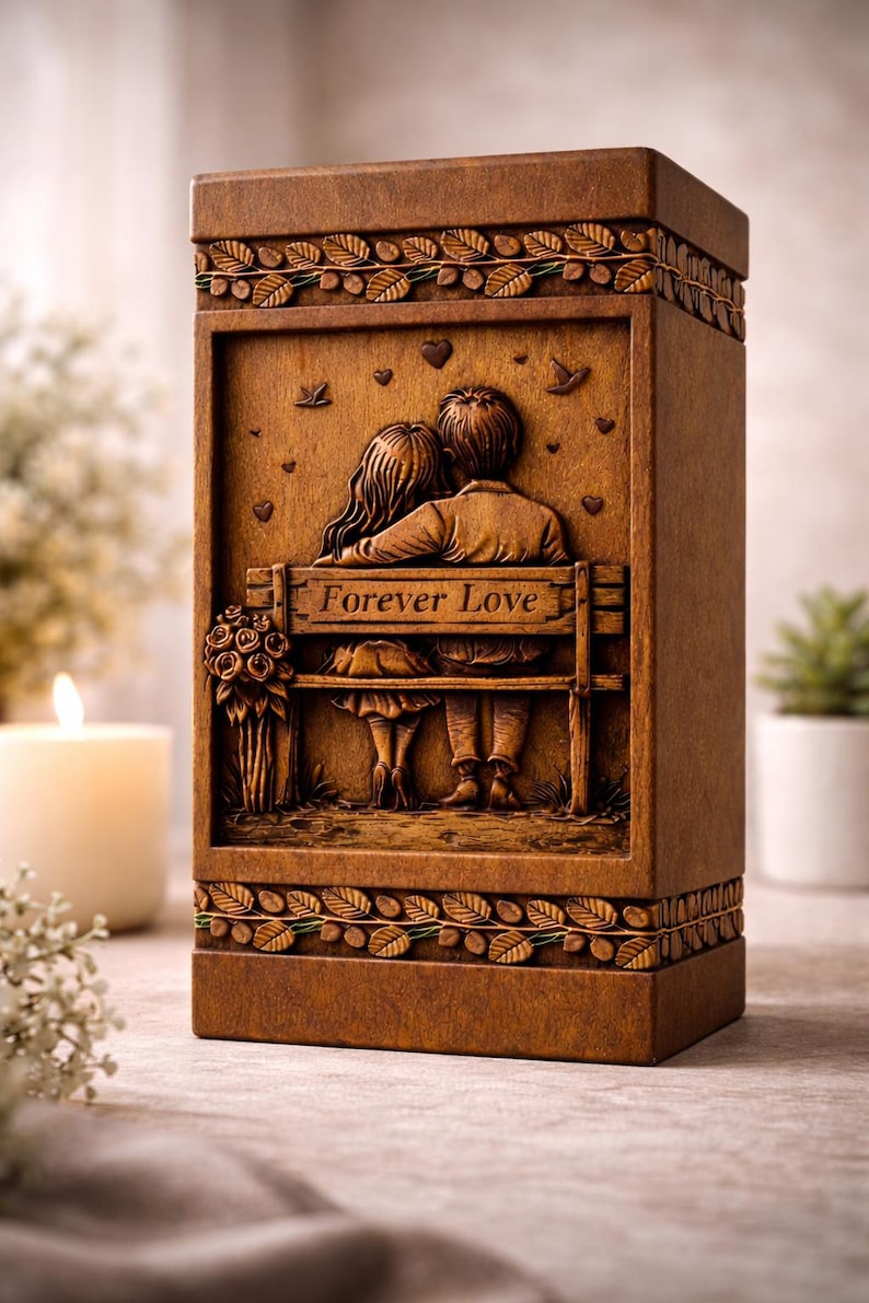 Puede incluir: Caja rectangular de madera marr&oacute;n con un relieve tallado de una pareja en un banco, con las palabras "Forever Love". La caja tiene bordes decorativos de hojas y vides.