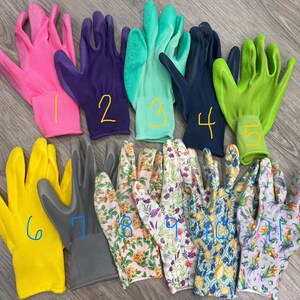 May include: A collection of gardening gloves in various colors and patterns. The gloves include solid colors like pink, purple, teal, navy, yellow, and gray, as well as floral designs. Each glove is numbered with a yellow marker.