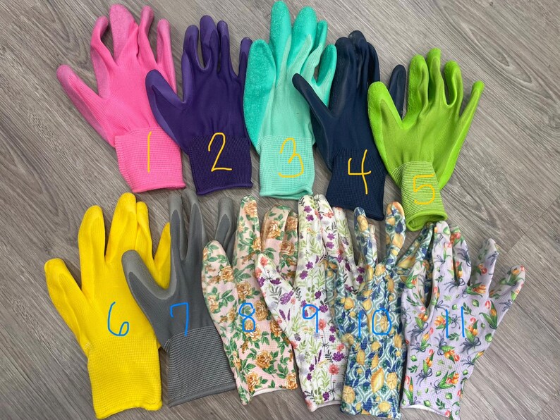 May include: A collection of gardening gloves in various colors and patterns. The gloves include solid colors like pink, purple, teal, navy, yellow, and gray, as well as floral designs. Each glove is numbered with a yellow marker.