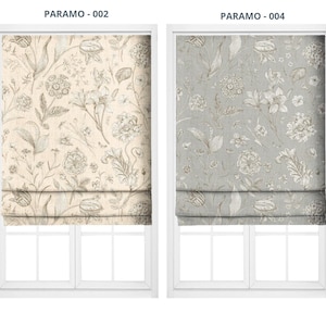 May include: Two window treatments with floral patterns. The left window treatment is beige with a detailed botanical design. The right window treatment is gray with a similar floral pattern. Both are displayed in white window frames.