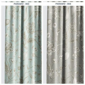 May include: Two floral patterned curtain panels. One panel is a light teal color with beige and white floral designs. The other panel is a light gray color with white and beige floral designs. The text "PARAMO - 003" and "PARAMO - 004" are visible at the top.